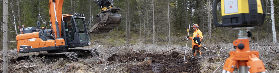 Grävmaskin och arbetare som jobbar med en dikespluggning.